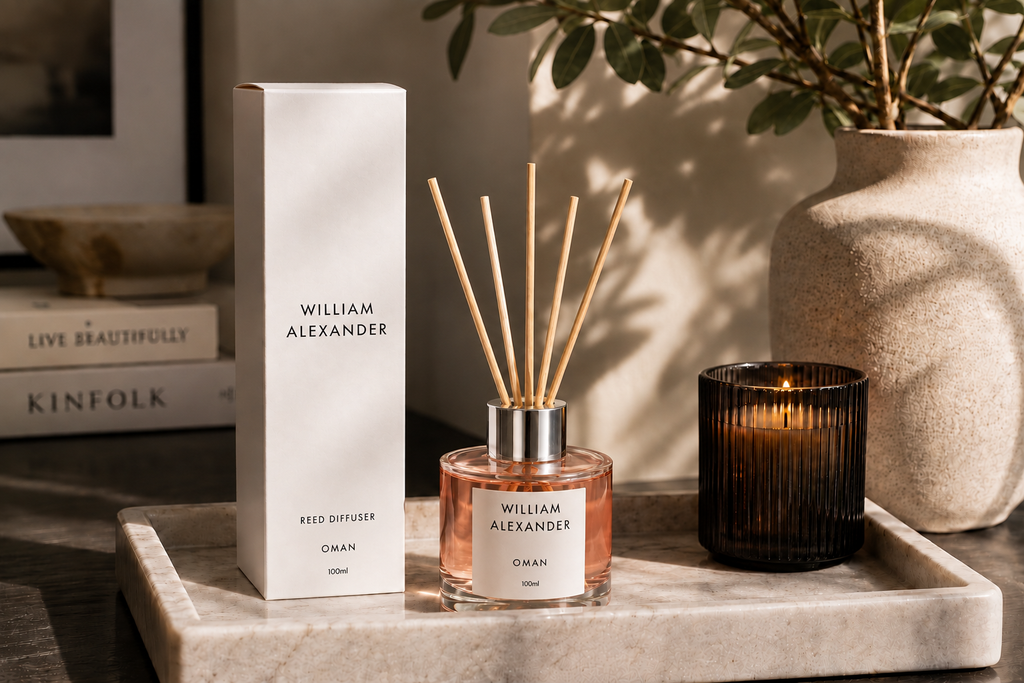 Oman Rose Oud Reed Diffuser 120ml on a marble tray with a candle and books in a living room